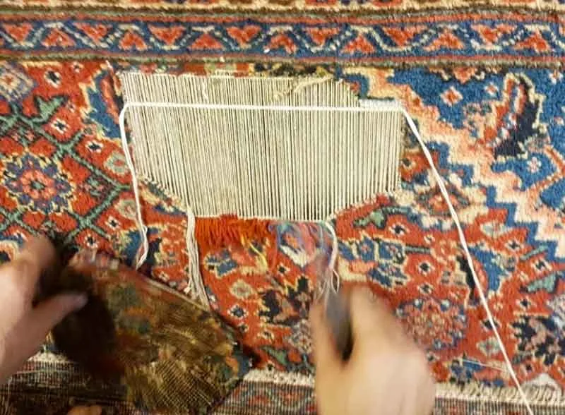 Artisan en train de réparer un tapis à la main